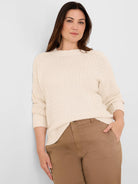 Off-white, loose-fitting criss cross sweater with a varied textured knit, crew neck, and ribbed cuffs/hem.