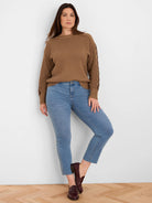Brown sweater with a textured knit and prominent criss-cross details on sleeves.