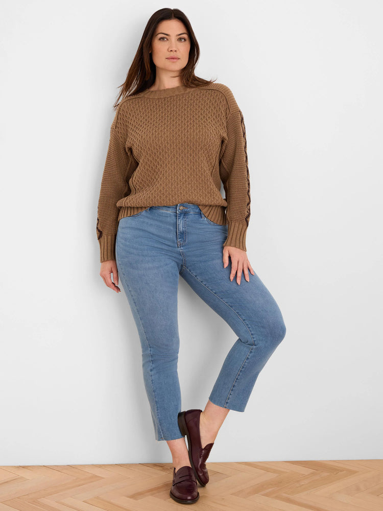 Brown sweater with a textured knit and prominent criss-cross details on sleeves.