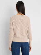Light beige open-knit sweater with a repeating diamond pattern, ribbed hem and cuffs. Seen from the back.