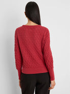 Deep red sweater with open-knit diamond pattern, ribbed cuffs and hem. Worn by model, back view.