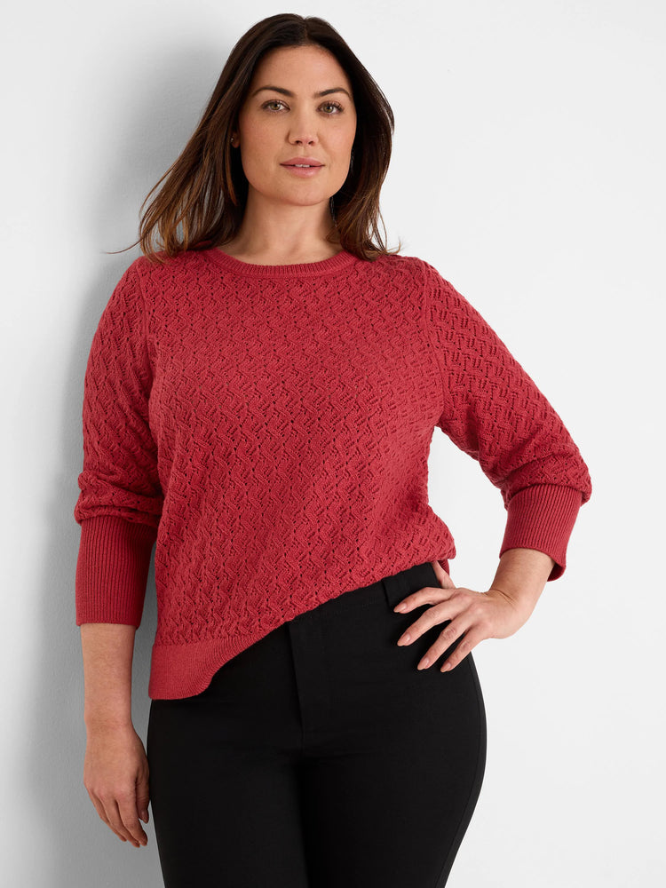 Rust red crew neck sweater with an all-over open-knit diamond pattern and ribbed cuffs & hem.