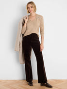 Light beige shimmer sweater with a V-neck and decorative clip cinching the shoulder.