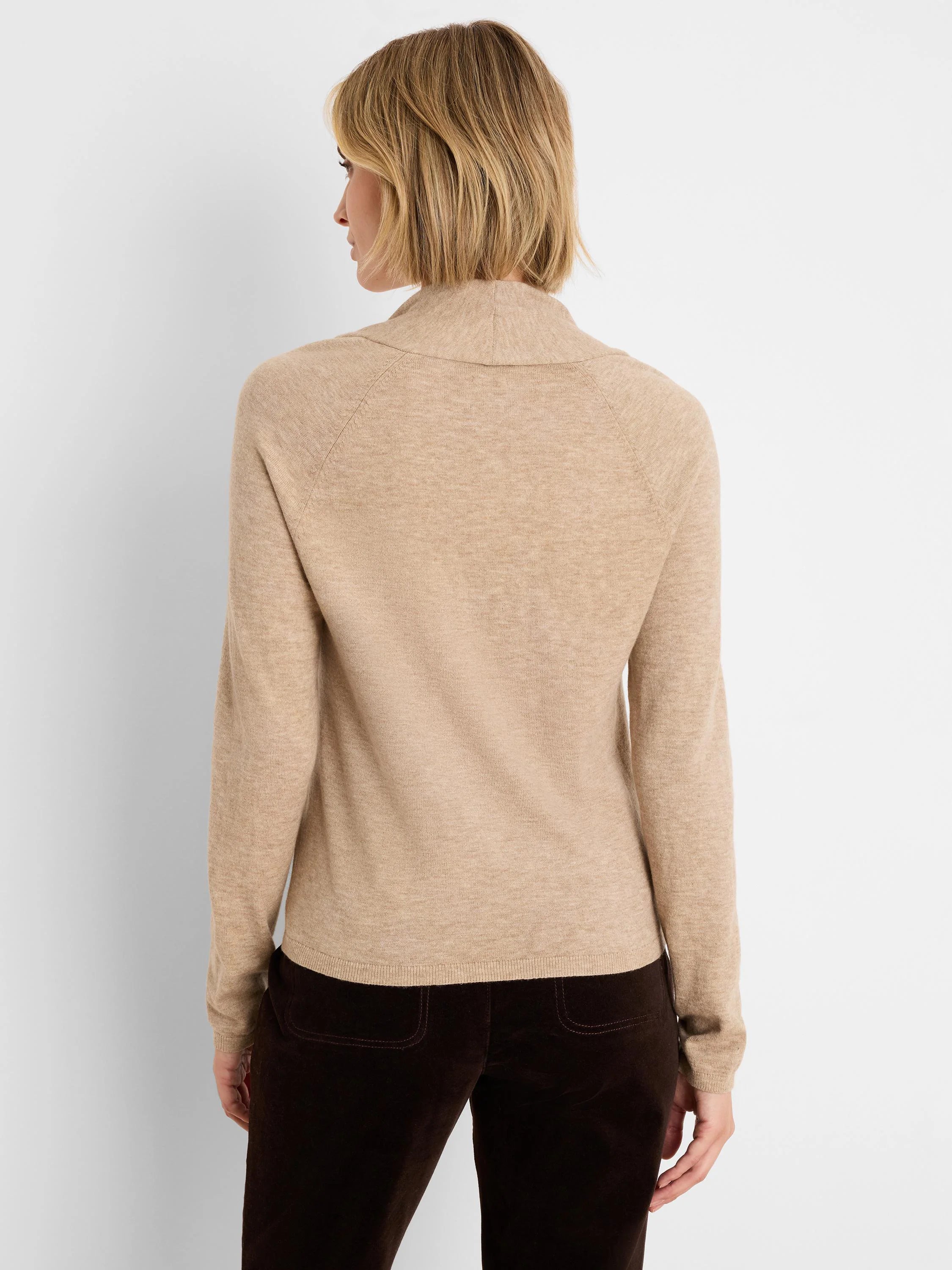 Beige fine knit sweater with a high, soft collar and raglan sleeves, shown from the back.