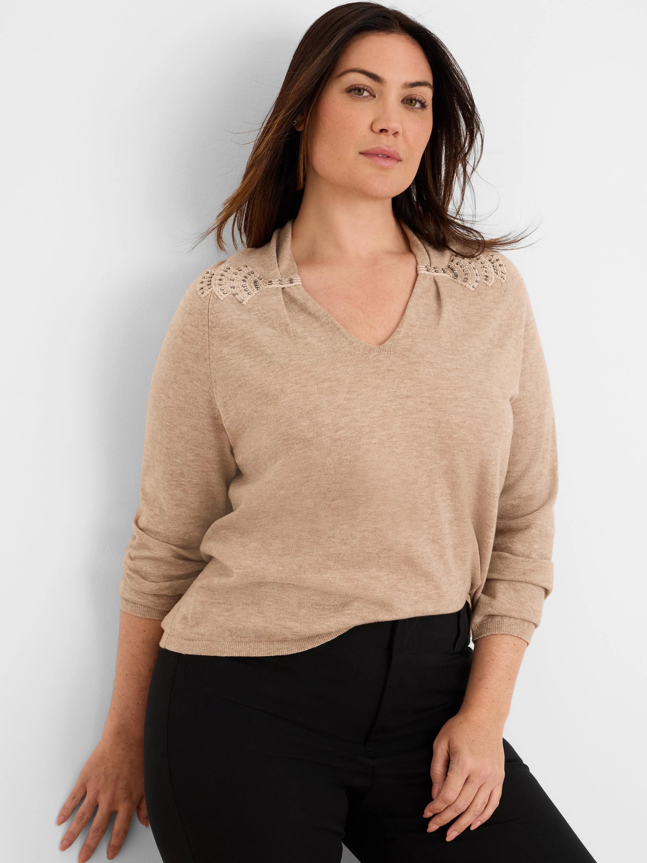 Beige V-neck sweater with beaded, cinched shoulder details.