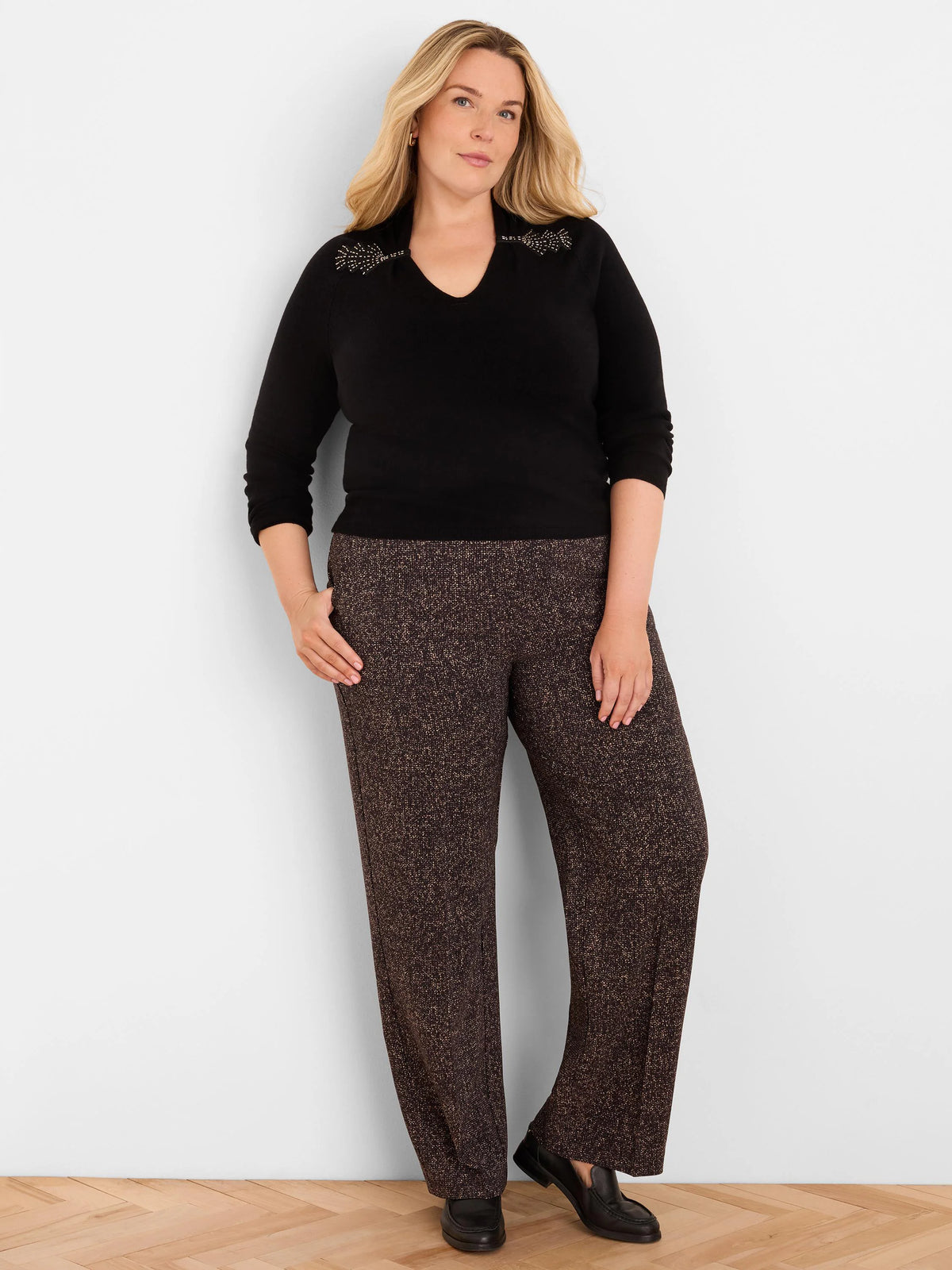 Black V-neck sweater with gold beaded embellishments on the shoulders.