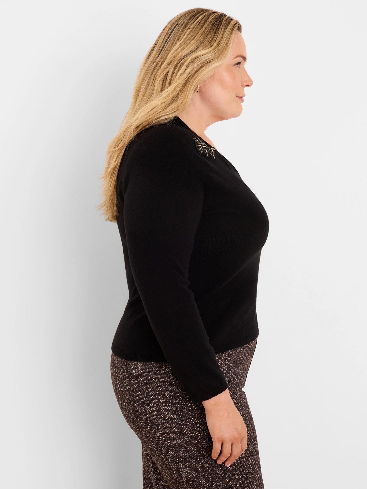 Fitted black V-neck sweater with gold beaded embellishment on the left shoulder.