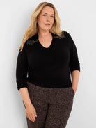Black V-neck sweater with shimmering beaded collar flaps and 3/4 sleeves.