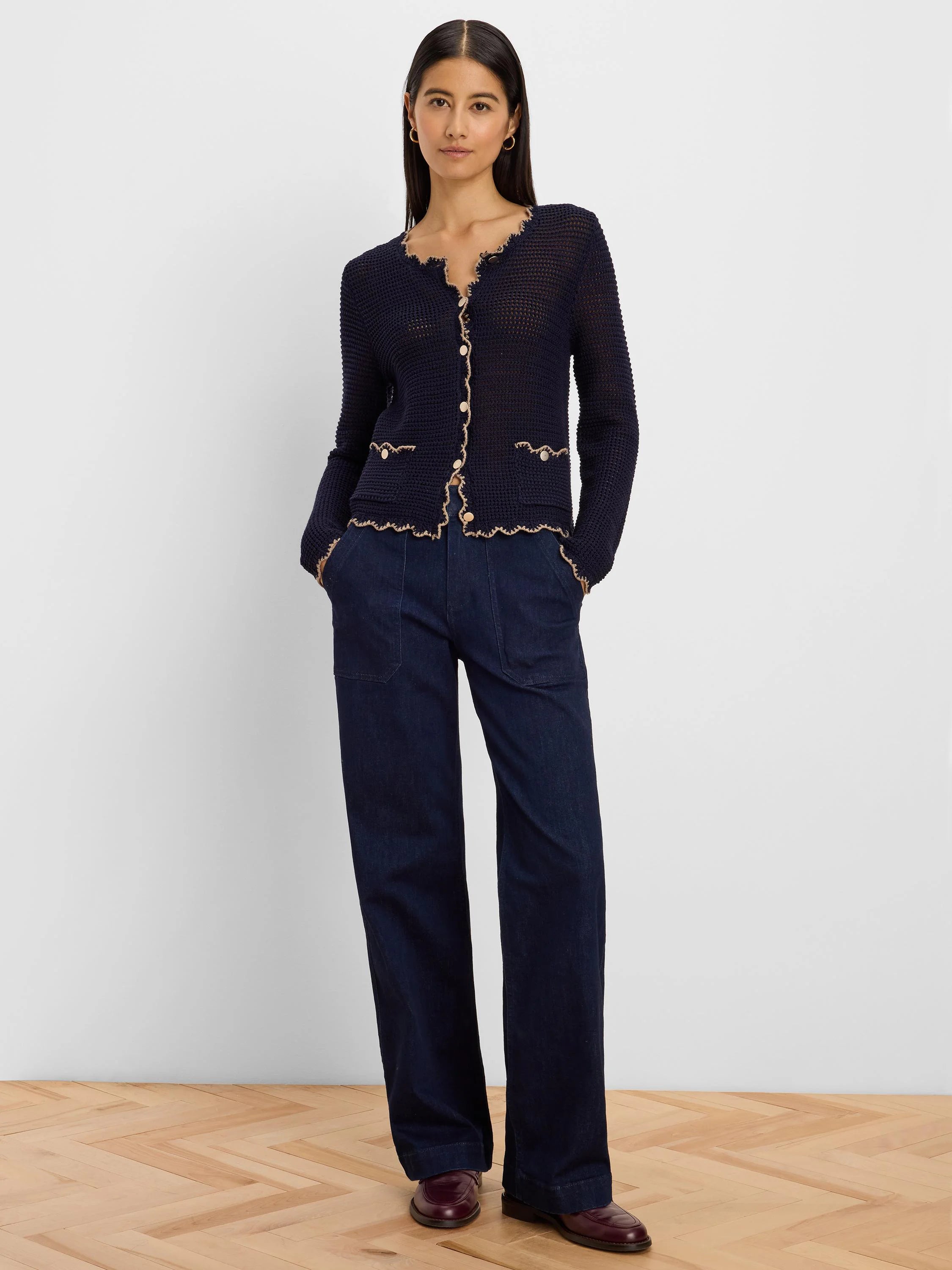 Navy mesh cardigan with scalloped beige trim, light buttons, and two front pockets.