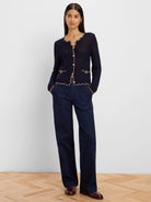 Navy mesh cardigan with scalloped beige trim, light buttons, and two front pockets.