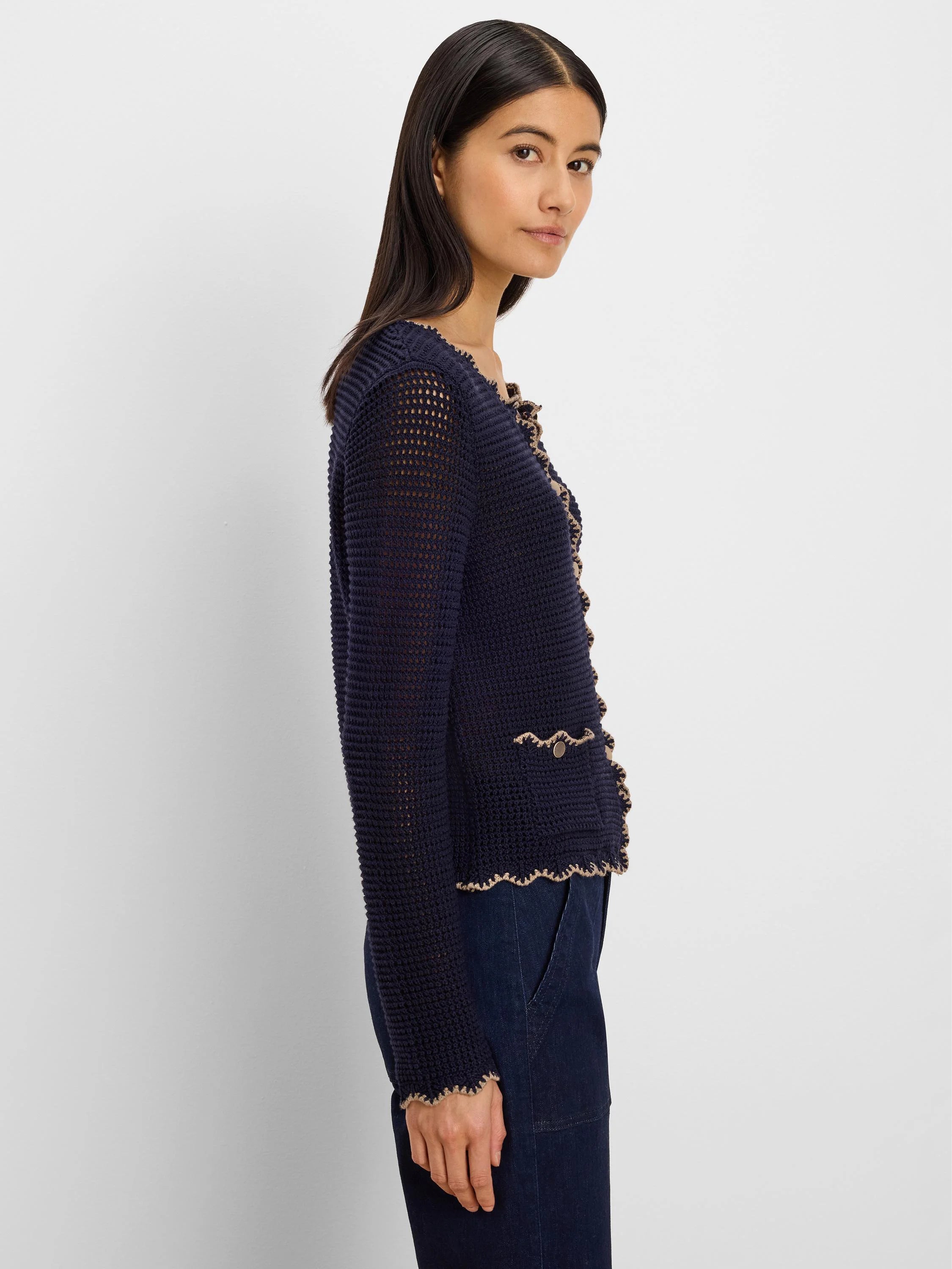 Navy open-knit cardigan with beige wavy trim on front, hem, cuffs, and faux pockets, plus small gold buttons.
