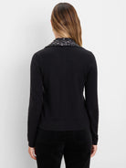 Black cardigan with dark sequin collar, long sleeves, and ribbed trim, worn by a model from the back.
