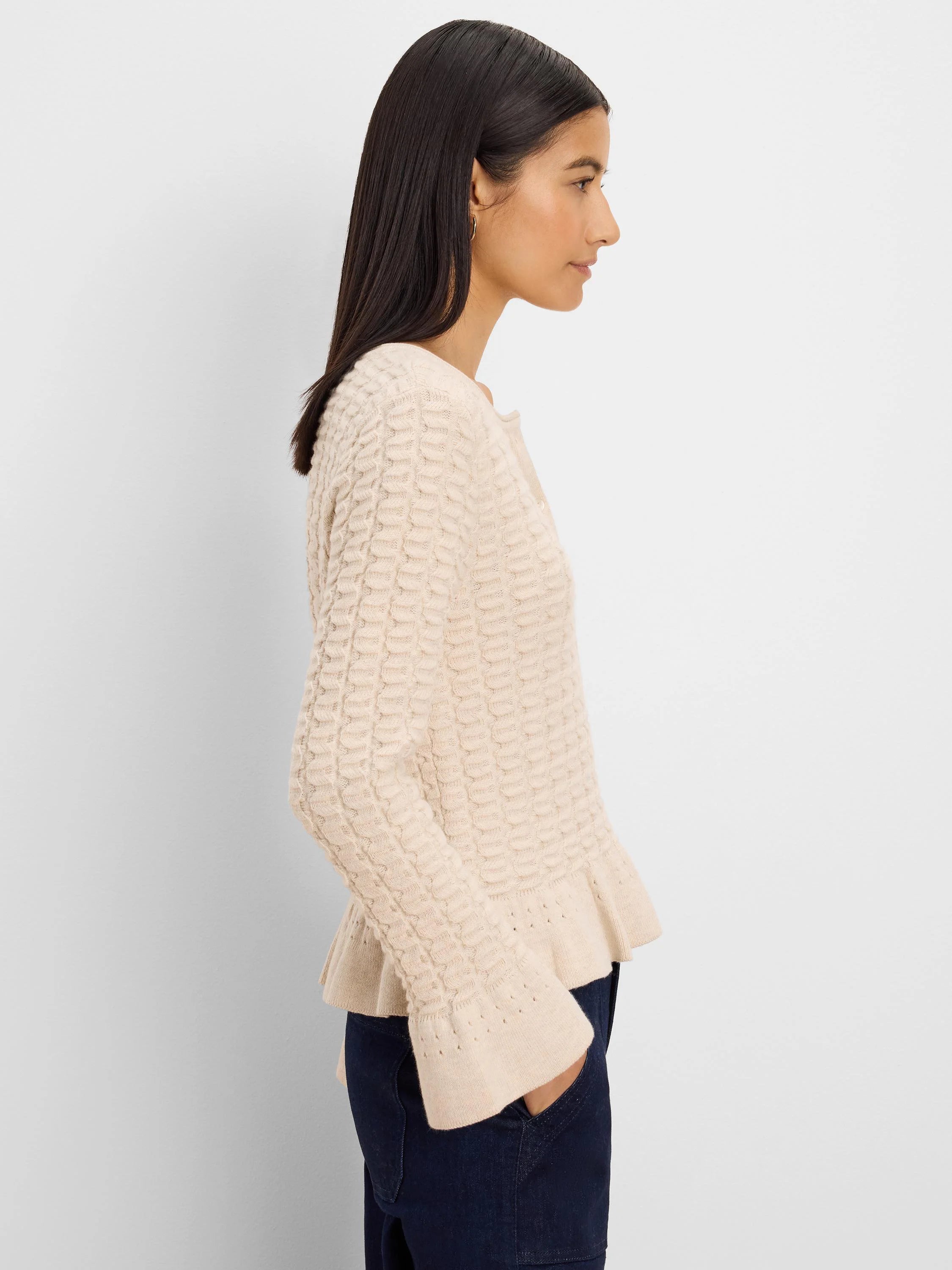 Pale beige cardigan with raised knit texture, frilled hem & cuffs, and front buttons.