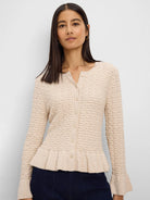 Cream textured knit cardigan with button front, V-neck, ruffled peplum hem, and flared cuffs.