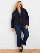 Angled tan & black diamond jacquard sweater with V-neck and gold buttons.