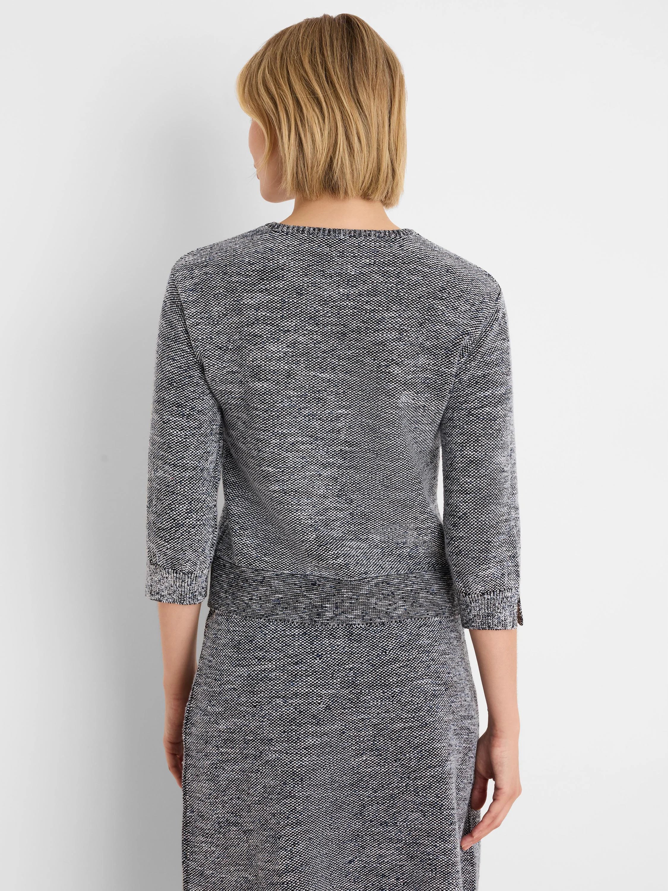 Tweed stitch sweater in speckled black, white, and blue with a round neck and 3/4 sleeves.