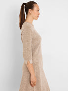 Speckled beige and brown knit sweater with 3/4 sleeves, a round neckline, and small slits at the cuffs.