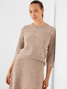 Light brown tweed stitch sweater with subtle darker flecks, a crew neck, and 3/4 sleeves.