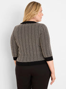 Black and cream geo stitch sweater with 3/4 sleeves and ribbed black trim on collar, cuffs, and hem.