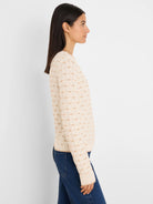 Cream sweater with a textured tan diamond tuck knit pattern.