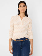 Cream cable tuck sweater with tan textured diamond pattern. Features a Henley neckline with 4 buttons and ruffled trim.