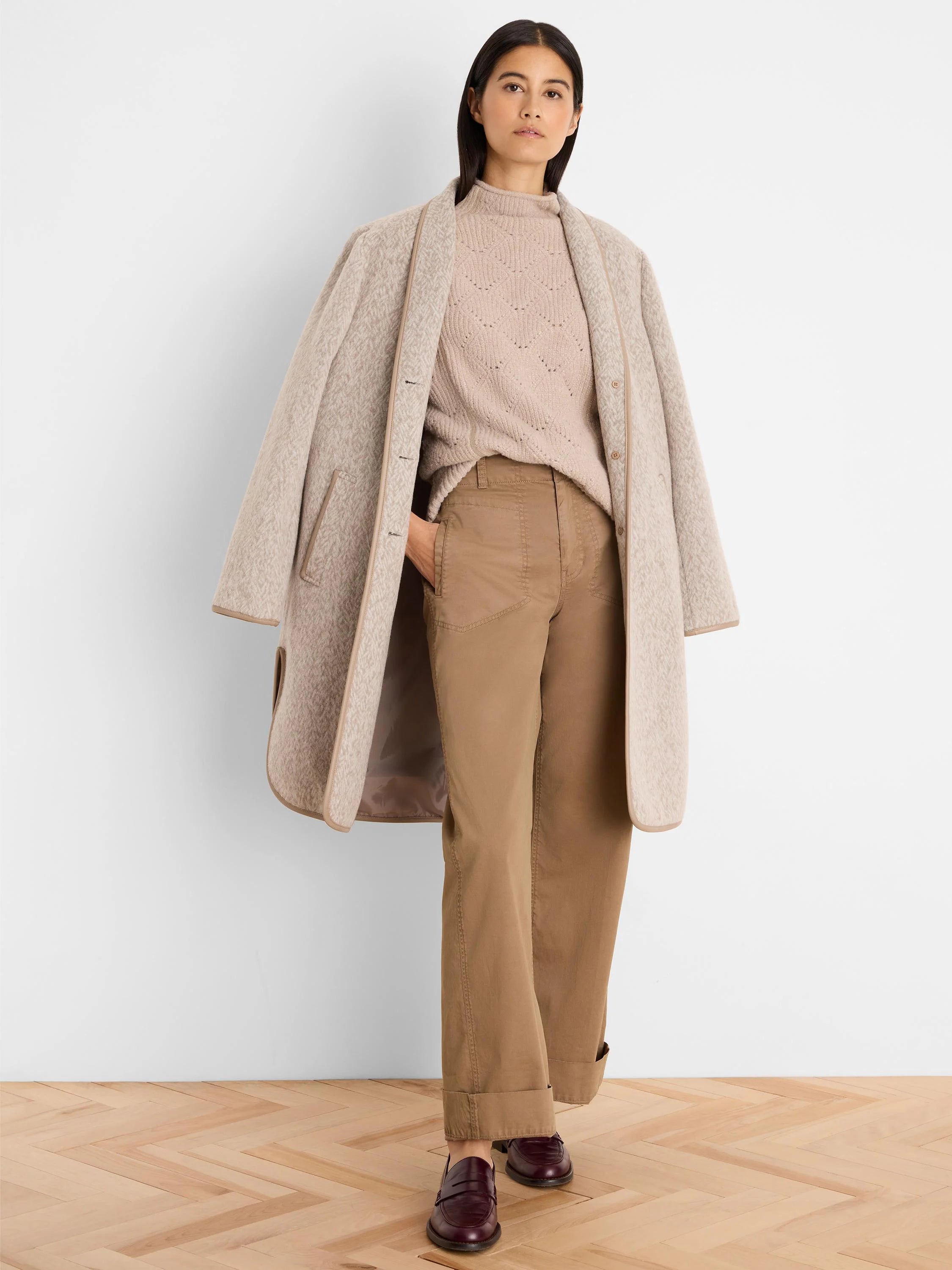 Light beige mock neck sweater with subtle diamond knit pattern.