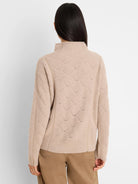 Beige high-neck sweater featuring an openwork diamond knit pattern, modeled from the back.