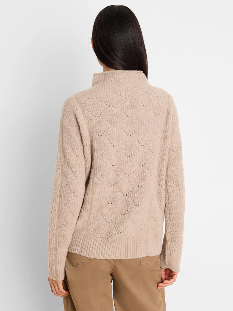 Beige high-neck sweater featuring an openwork diamond knit pattern, modeled from the back.