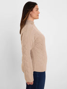 Beige mock neck sweater featuring a diamond knit pattern, worn by model.