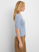 Light blue V-neck, elbow sleeves, exposed shoulder/side seams, and ribbed edges.