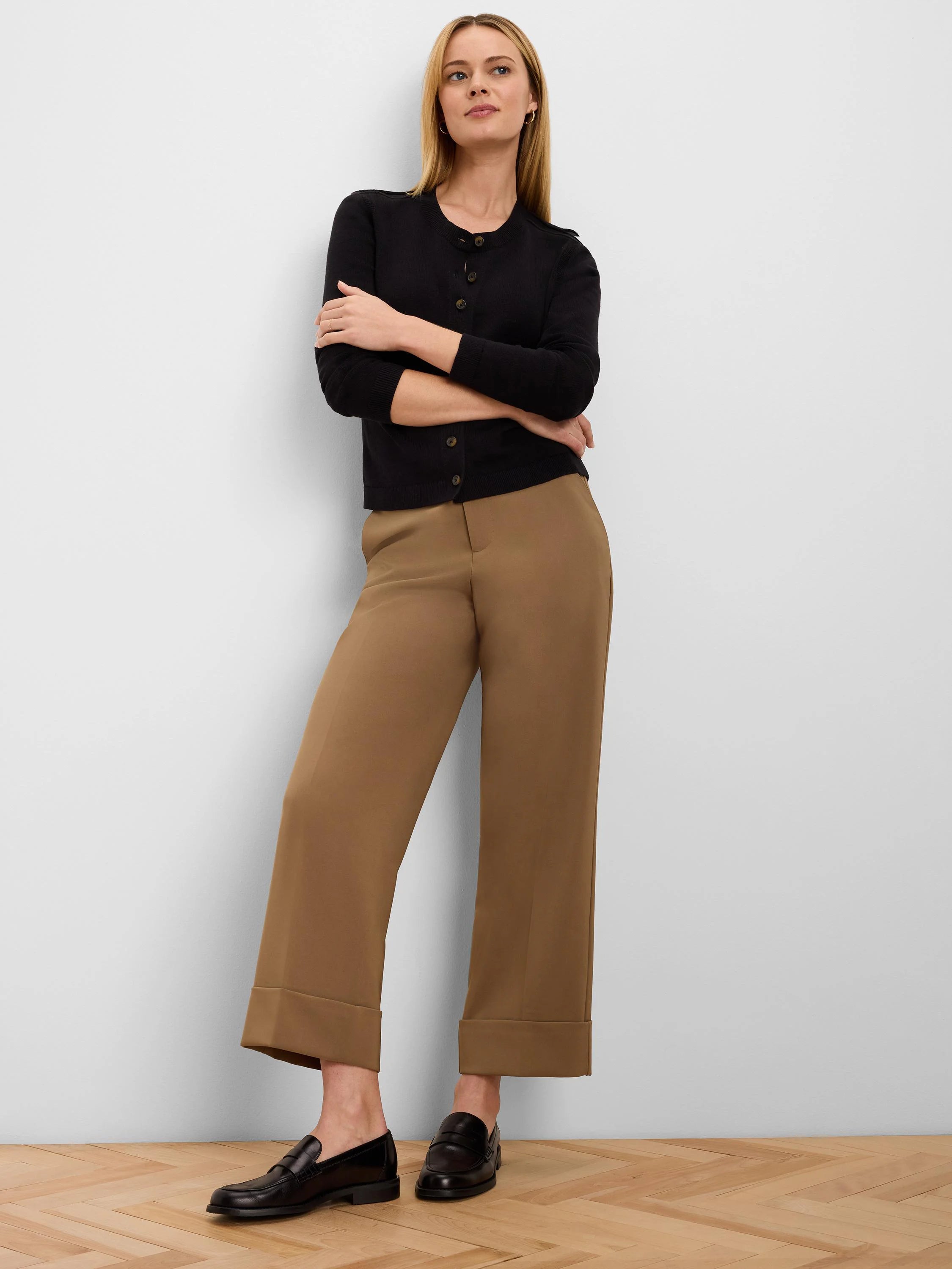 Black button-up cardigan with brown buttons. Features 3/4 length ribbed sleeves.