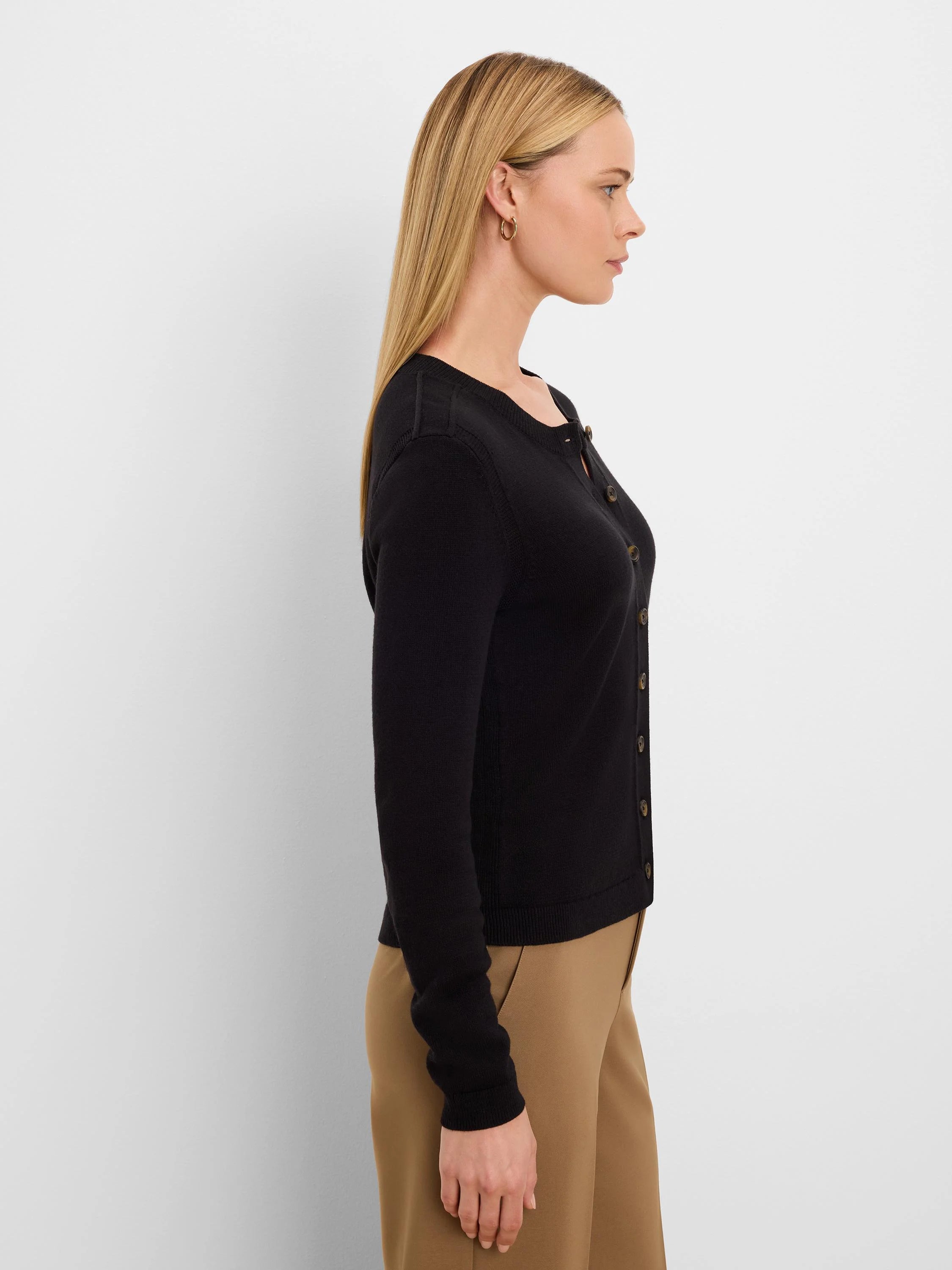 Black button-up cardigan with a round neck and long sleeves. Features contrasting light brown buttons.