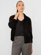 Black knit open-front cardigan with relaxed long sleeves and ribbed cuffs.