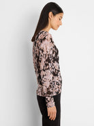 Long-sleeve sweater with an abstract mottled pattern in pink, black, and beige, featuring subtle shimmer.