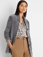 Speckled black & white tweed sweater jacket with visible dark buttons.