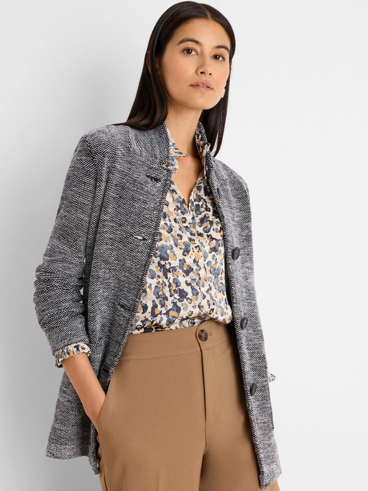 Speckled black & white tweed sweater jacket with visible dark buttons.