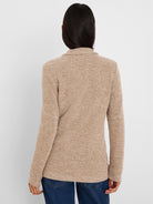 Back of a light brown tweed stitch sweater jacket with dark flecks and a textured knit.