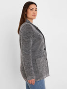 Black and white tweed stitch sweater jacket, open front, with two dark buttons and front patch pockets.