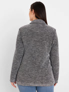 Back of a collared black and white tweed sweater jacket with a textured, speckled pattern.