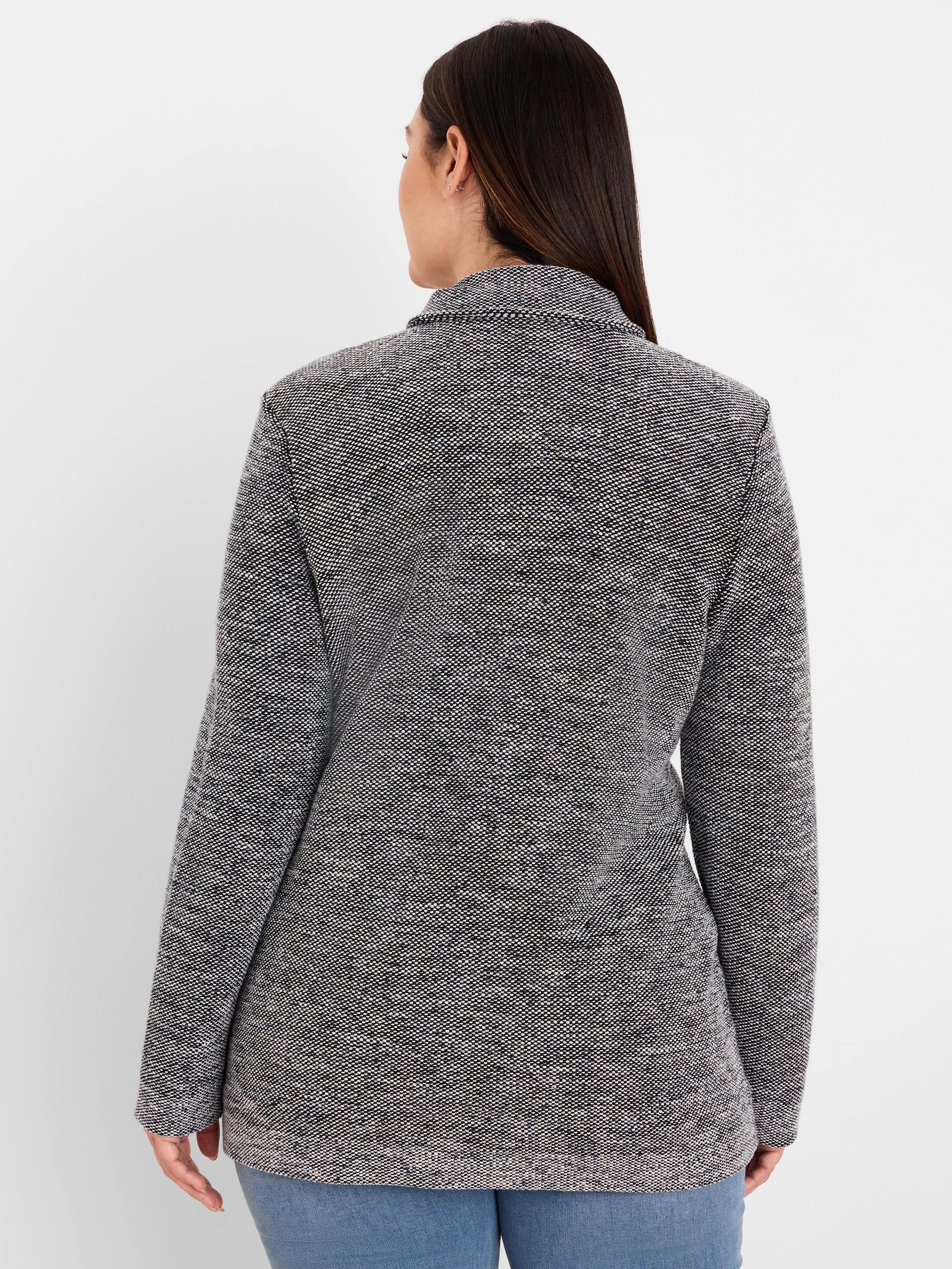 Back of a collared black and white tweed sweater jacket with a textured, speckled pattern.