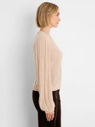 Light beige sweater with voluminous cable knit sleeves and an openwork body.