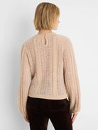 Light beige sweater, mixed cable and open-stitch knit, keyhole button at back neck.