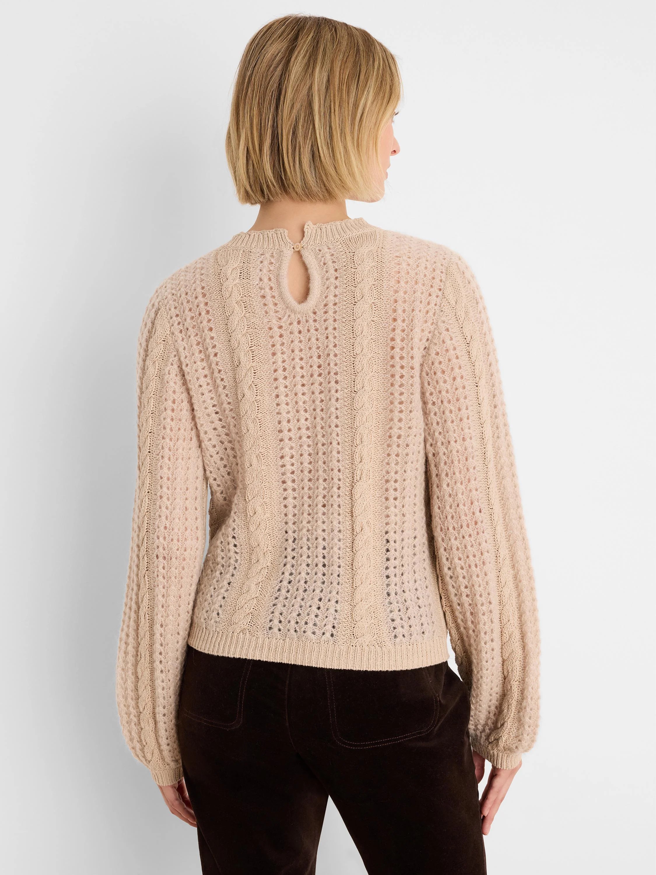Light beige sweater, mixed cable and open-stitch knit, keyhole button at back neck.