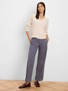 Light cream V-neck sweater with a ribbed knit texture and relaxed fit.