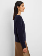 Navy blue ribbed knit sweater with long sleeves, worn by a model.