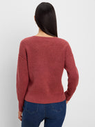 Rust ribbed knit sweater seen from the back on a model wearing jeans. Features a wide scoop neckline.
