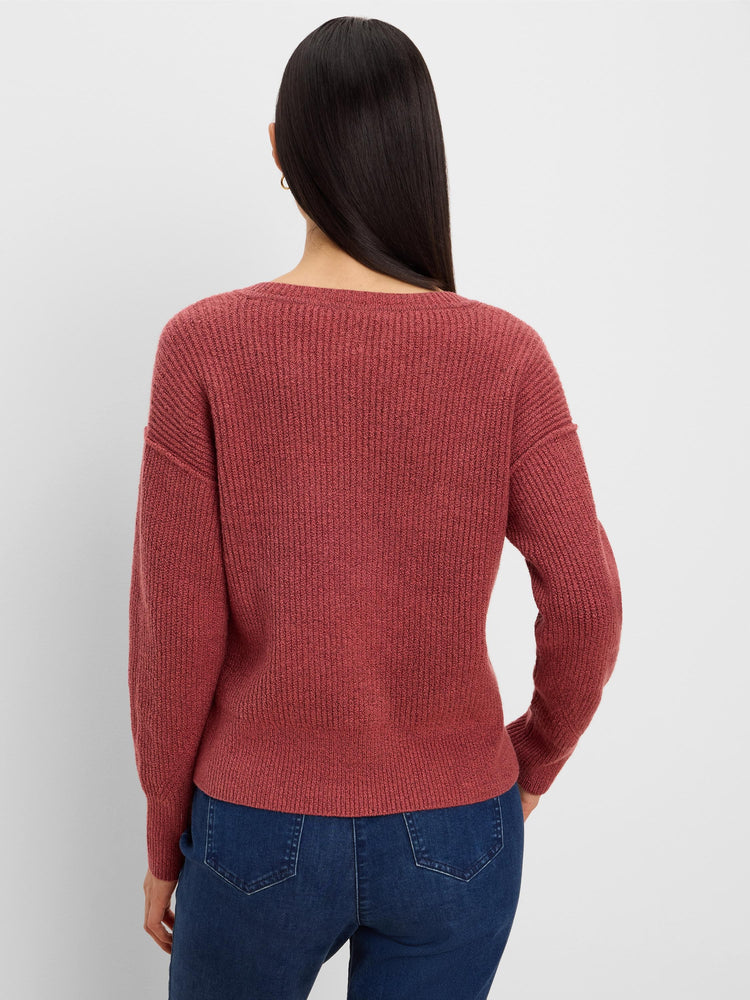 Rust ribbed knit sweater seen from the back on a model wearing jeans. Features a wide scoop neckline.
