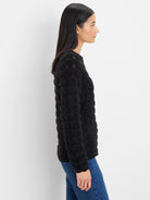 Black fuzzy long-sleeve sweater with small openwork details on the upper chest.