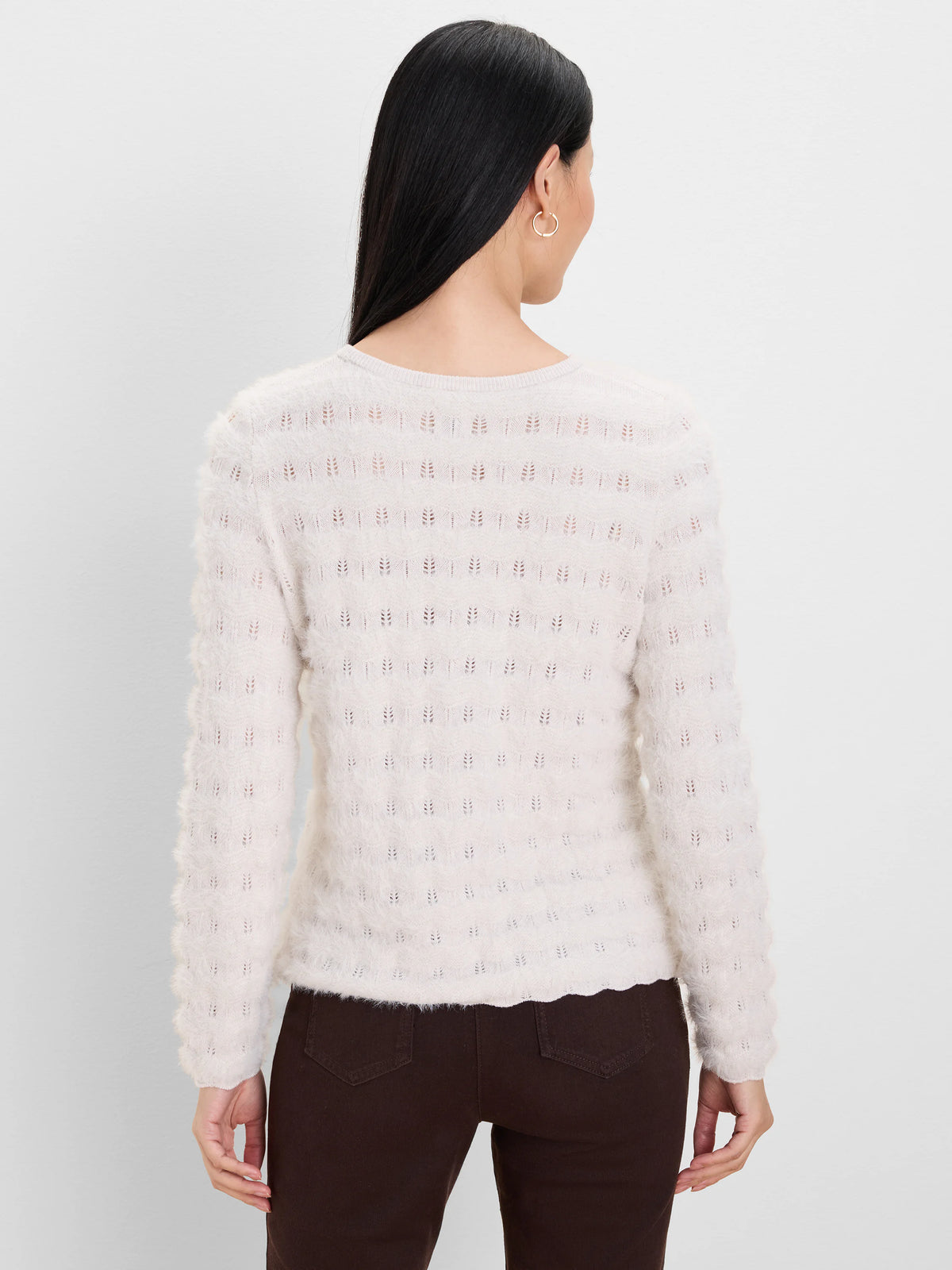 Ecru fuzzy knit sweater with openwork rows of small leaf-like patterns. Model from behind.