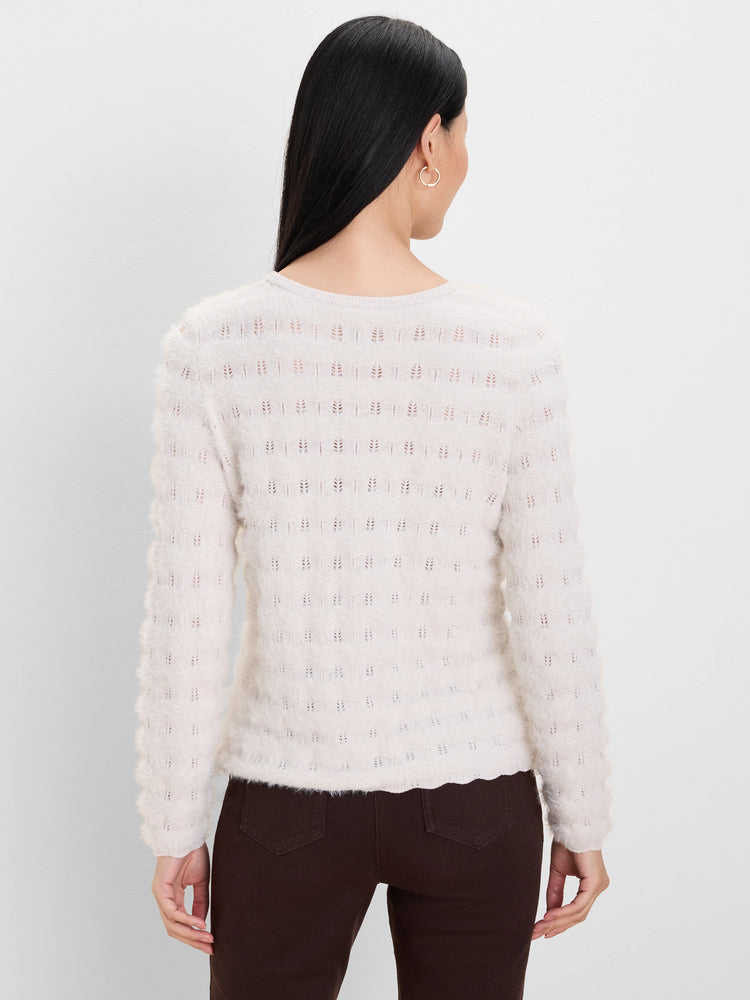 Ecru fuzzy knit sweater with openwork rows of small leaf-like patterns. Model from behind.